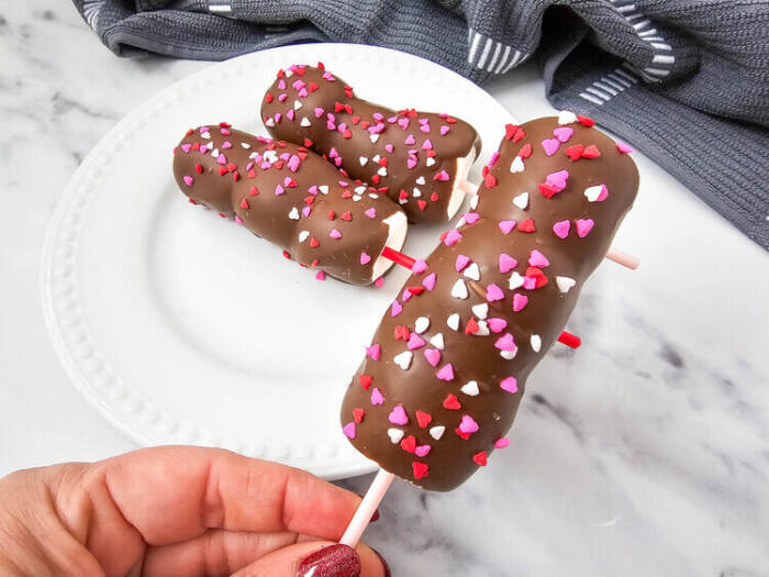 Valentine’s-themed marshmallow pops with pink and red candy and sprinkles on sticks