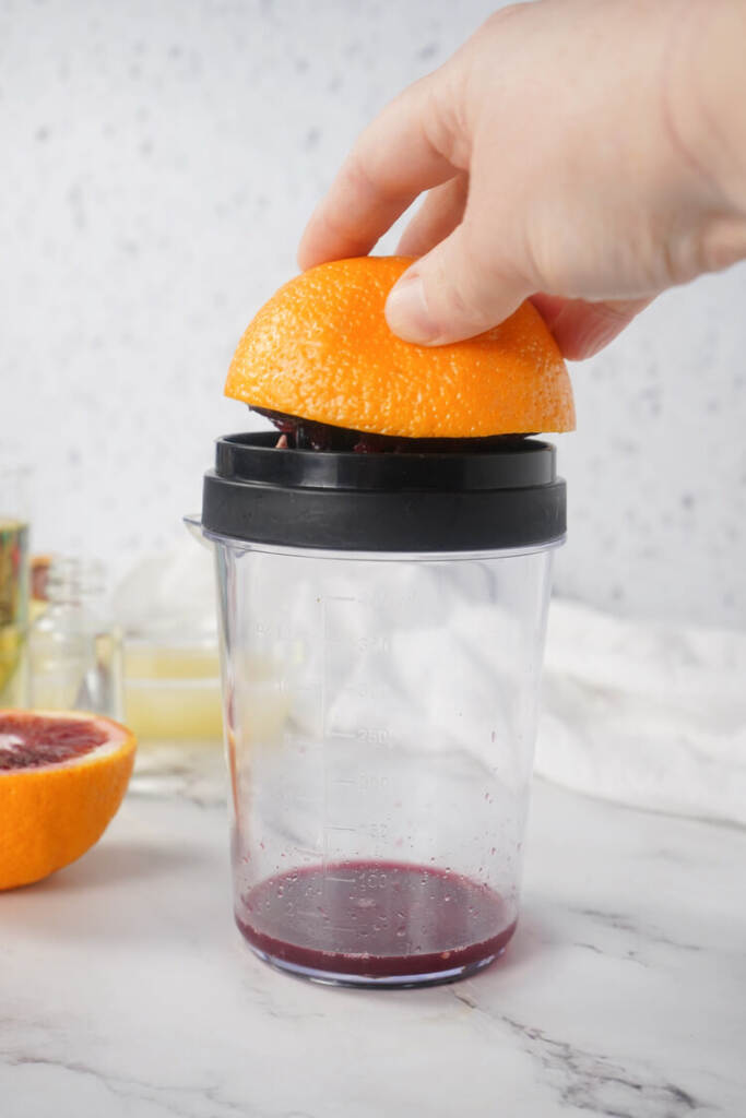 juicing the orange into a juicer