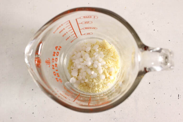 Cocoa butter and cetyl alcohol pellets in a glass measuring cup