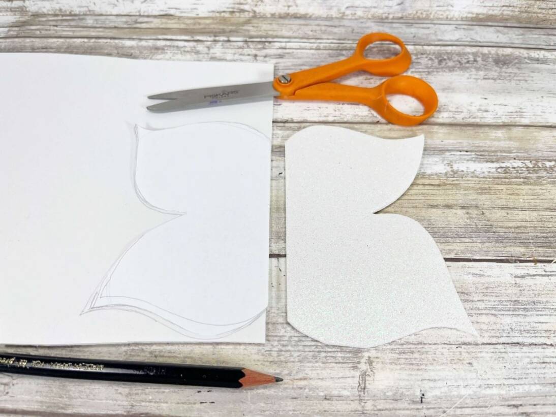 A piece of paper cut into butterfly wings for popsicle stick butterfly craft.
