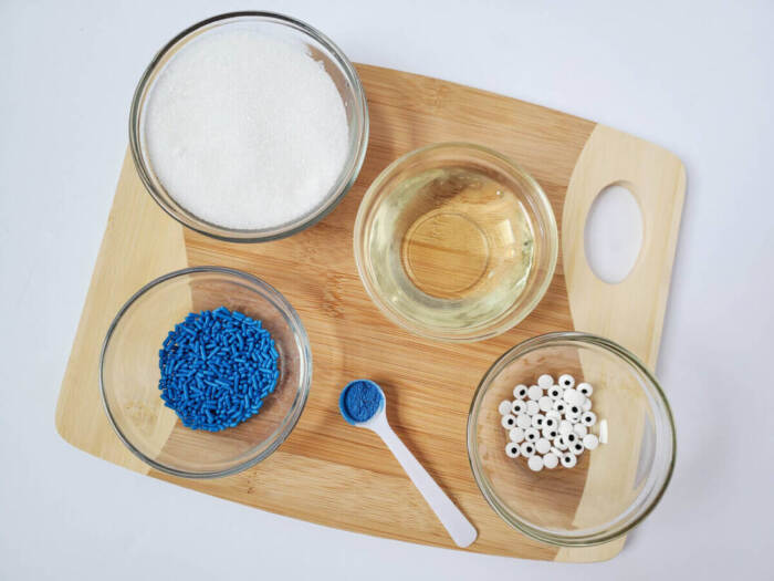 sugar scrub ingredients in glass bowls on wooden board