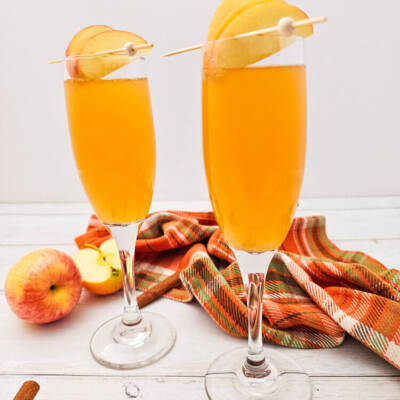 Two champagne flutes of apple cider mimosas recipe