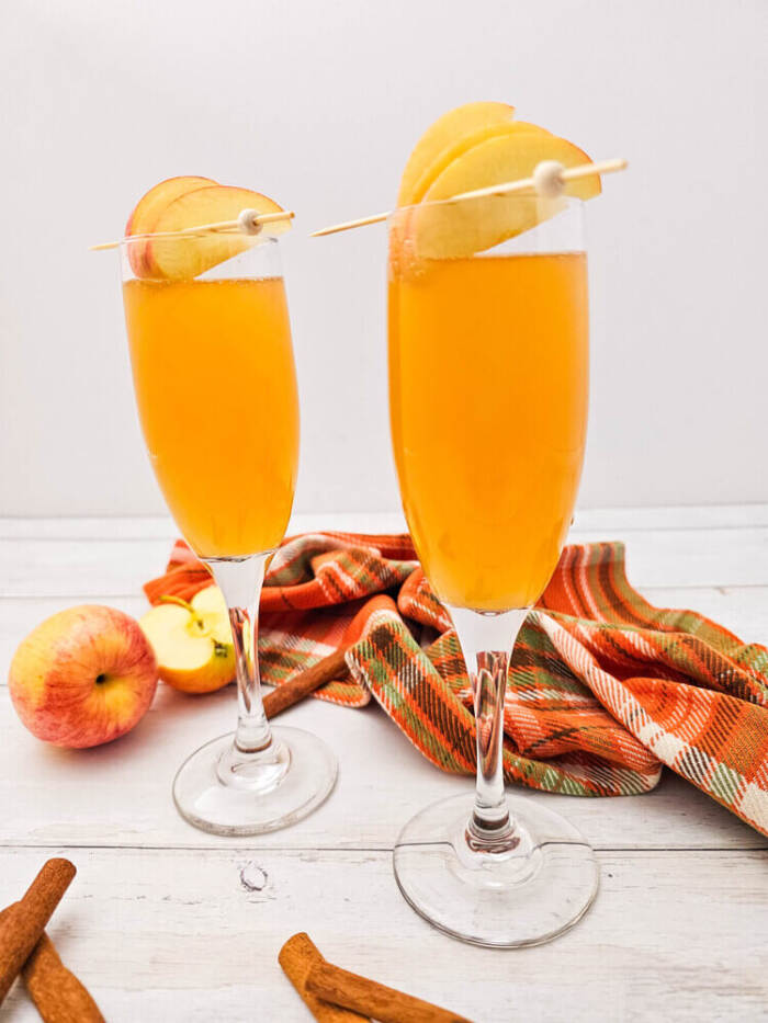 Two champagne flutes of apple cider mimosas recipe