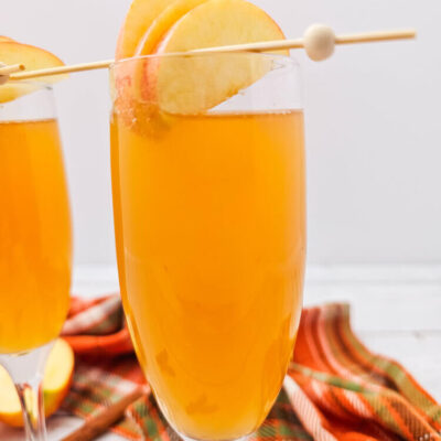A drink made with Apple cider mimosas recipe in a champagne flute.