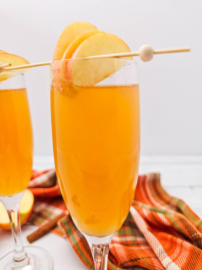 A drink made with Apple cider mimosas recipe in a champagne flute.