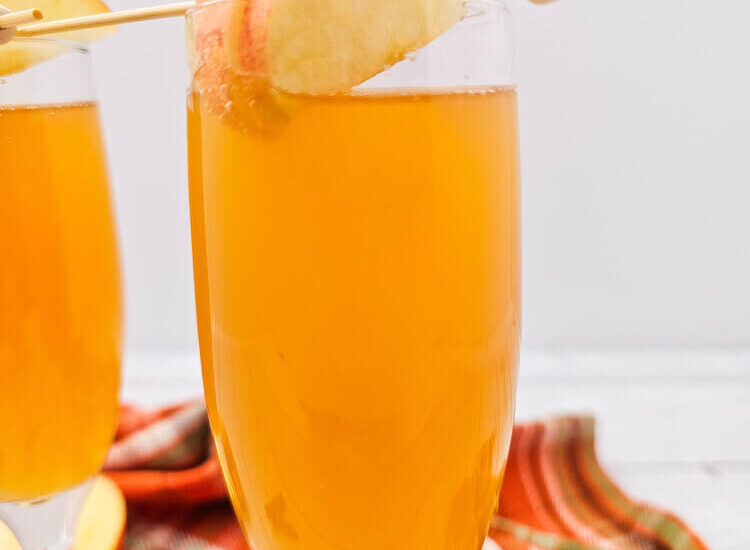 A drink made with Apple cider mimosas recipe in a champagne flute.