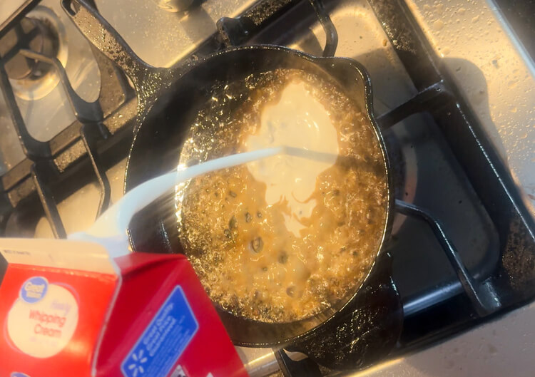 Heavy cream poured into a skillet for Copycat Applebee's O-M-Cheese Burger.