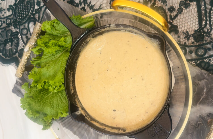 A skillet filled with melted cheese for Copycat Applebee's O-M-Cheese Burger.