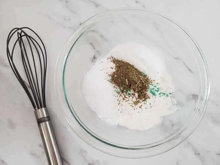 A bowl with dry ingredients for eucalyptus bath bombs.