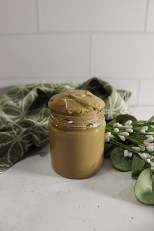 A jar of poison ivy paste diy on a table.